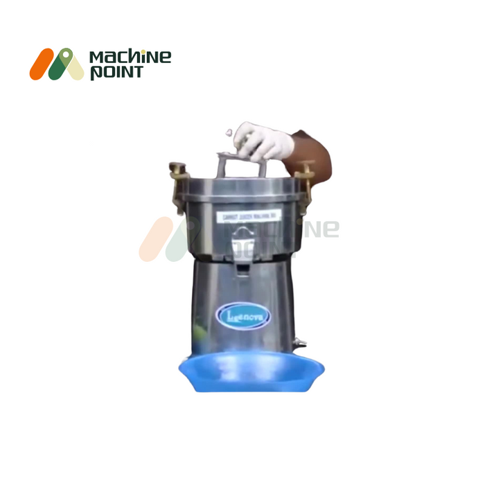 Small-sized commercial carrot juice extractor in operation with hand on handle.