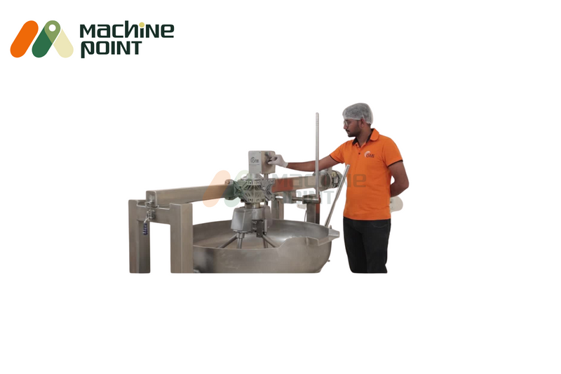 Operator managing control panel of 4-feet halwa machine equipped with electric stirring arm and large cooking pan.