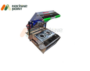 Double Cup Sealing Machine – Compact stainless steel unit with dual sealing slots and ergonomic handle, ideal for fast beverage packaging.