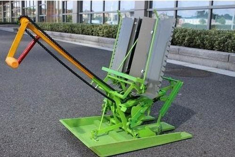 Compact Two Row Manual Rice Transplanter in green and orange, designed for efficient agricultural operations, placed on a paved urban setting.